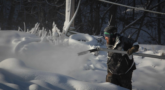 Alex Weir adjusts the snow gun near the top of  a trail.