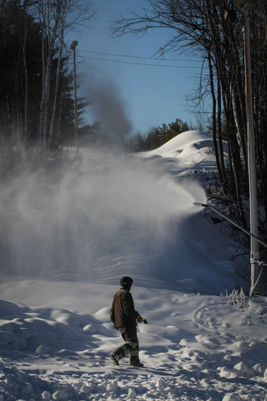 Workers move snow guns to help cover the trails at Mount Pakenham.