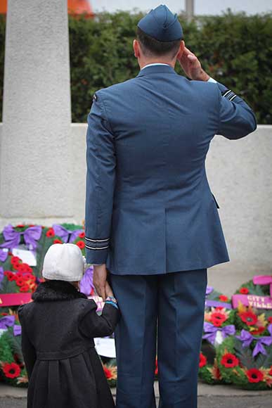 A veteran and his daughter take a moment to salute after the ceremonies have concluded. 