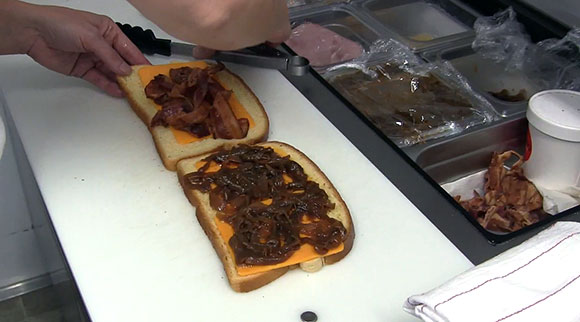 Carroll whips up a gourmet grilled cheese. Yes, that's bacon and caramelized onion. (Photo by Jordan Mady)