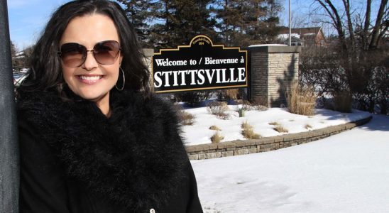 Sandra Plagakis, morning host on KiSS 105.3 in Ottawa, stands in front of the Stittsville sign